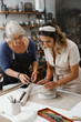 © ninelutsk - People working with clay on the table. Woman on pottery workshop in studio. Adults learning to do ceramic plates. Pottery as hobby and leisure activity