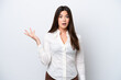 © luismolinero - Young Brazilian woman isolated on white background making doubts gesture