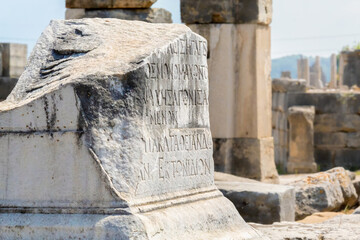 Sticker - Ancient Greek inscription carved on the stone. defocused ruins at the background. Perge, or Perga is ancient Anatolian city in Pamphylia. Antalya region, Turkey (Turkiye). Selected focus, copy space