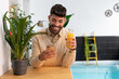 © ADDICTIVE STOCK - Young ethnic man messaging on smartphone and with a juice