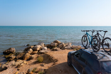 Two bikes on the roof rack of a car against a beautiful nature.