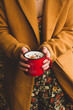 © ADDICTIVE STOCK - Woman with enamel cup of tasty beverage in garden