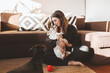 © ADDICTIVE STOCK - Young woman kissing dog near sofa