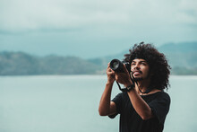 Black Photographer Taking Photo Of Sea On Professional Camera