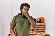 African man with curly hair wearing sportswear at the gym bored yawning tired covering mouth with hand. restless and sleepiness.
