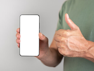 Poster - Man holding phone mockup with thumb up gesture. Male recommending, approving smartphone application
