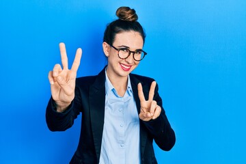 Poster - Young hispanic girl wearing business clothes and glasses smiling looking to the camera showing fingers doing victory sign. number two.