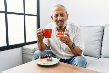 Sticker - Senior grey-haired man smiling confident having breakfast at home