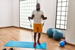 Young african american man training with elastic band at sport center