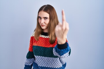 Canvas Print - Young hispanic girl standing over blue background showing middle finger, impolite and rude fuck off expression