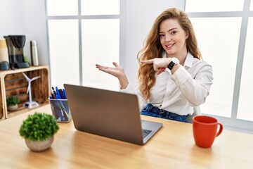 Sticker - Young caucasian woman working at the office using computer laptop amazed and smiling to the camera while presenting with hand and pointing with finger.