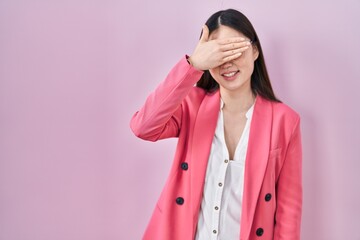 Poster - Chinese business young woman wearing glasses smiling and laughing with hand on face covering eyes for surprise. blind concept.