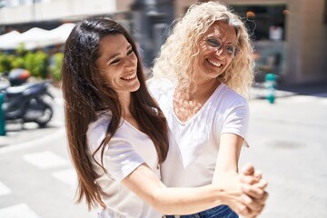 Two women mother and daughter dancing at street