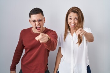 Canvas Print - Mother and son standing together over isolated background pointing displeased and frustrated to the camera, angry and furious with you