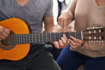 Wall Mural - Man and woman musicians having classic guitar lesson at music studio