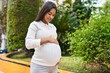 © Krakenimages.com - Young latin woman pregnant smiling confident touching belly at park