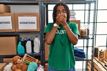 Poster - Young african american woman working wearing volunteer t shirt at donations stand shocked covering mouth with hands for mistake. secret concept.