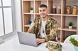 © Krakenimages.com - Young hispanic man army soldier using laptop sitting on table at home