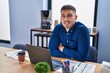 © Krakenimages.com - Young hispanic man business worker sitting with arms crossed gesture at office