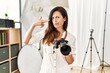 © Krakenimages.com - Beautiful caucasian woman working as photographer at photography studio shooting and killing oneself pointing hand and fingers to head like gun, suicide gesture.