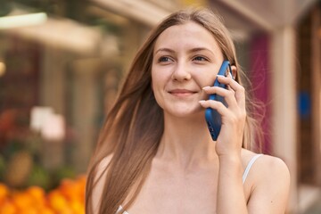 Canvas Print - Young caucasian woman smiling confident talking on the smartphone at street