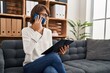 © Krakenimages.com - Young beautiful hispanic woman psychologist talking on smartphone reading document at psychology clinic