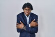 © Krakenimages.com - Young african man with dreadlocks wearing business jacket over white background shaking and freezing for winter cold with sad and shock expression on face