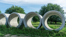 Reinforced Concrete Storm Sewer Pipes Of Large Diameter Stacked At A Construction Site. Sewer Large Diameter Pipes.