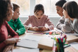 © Prostock-studio - Classmates Using Smartphone Sitting At Desk During Break In Classroom