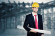Male architect carry blueprint on construction site