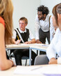 © track5 - Teenage Students, candid classroom. A genuine class scene with a teacher and pupil engaged with a third character. From a series of related images.