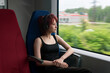 © Evgeny - girl rides on a commuter train and looks out the window at an outside landscape blurred in motion