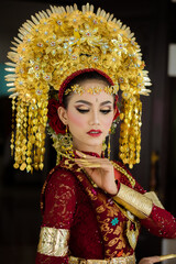 Wall Mural - A female model who wears make-up and a traditional wedding dress or attire. Traditional clothing of Bali - Indonesia. Balinese Culture
