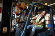 © offsuperphoto - female worker driving a forklift and looking to something in warehouse storage