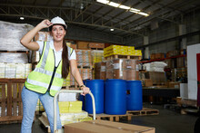 Female Factory Worker Pushing Cart With Corrugated Box In The Warehouse Storage
