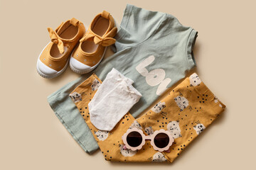 Poster - Stylish child clothes, shoes and accessories on beige background, flat lay