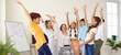 © Studio Romantic - Group of elementary school students and their female teacher raising their hands feeling spirit of unity. Joyful schoolboys and schoolgirls are having fun at creative lesson in modern school. Banner.
