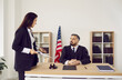 © Studio Romantic - Lawyer talking to judge in American courthouse. Serious young female attorney and male judge discussing trial process and legal procedures during trial session in court of law