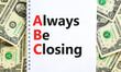 ABC always be closing symbol. Concept words ABC always be closing on white note on a beautiful background from dollar bills. Business and ABC always be closing concept. Copy space.