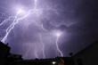 multiple large lightning strikes spanning in the night