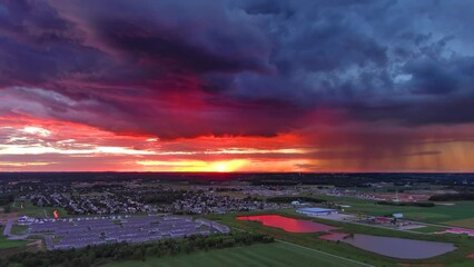 Wall Mural - Exceptionally beautiful red sunset with rain clouds over rural suburb at dusk, aerial view.
