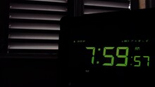 Young Man Pressing Snooze Button on Early Morning Digital Alarm Clock With Green Display. Close Up. 4K Resolution.