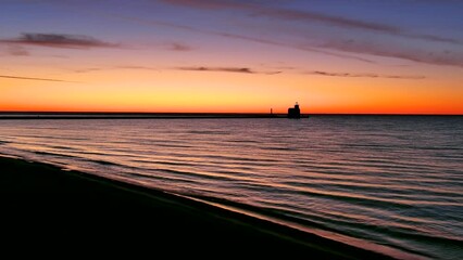 Wall Mural - Delicate waves ripple onto the beach at morning twilight, reflecting amazingly colorful dawn sky.
