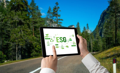 Green business transformation for environment saving and ESG business concept. Businessman using tablet to set corporate goal toward environmental friendly management and alternative clean energy use.