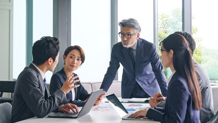 Aufkleber - 会議する幅広い世代のビジネスグループ