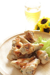 Wall Mural - Barbecue chicken drumsticks on wooden plate and glass of beer