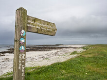 UK, Scotland, Directional Sign In Front Of Sandy Beach In Outer Hebrides