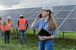 © Westend61 - Woman talking on mobile phone with coworkers in background at solar station