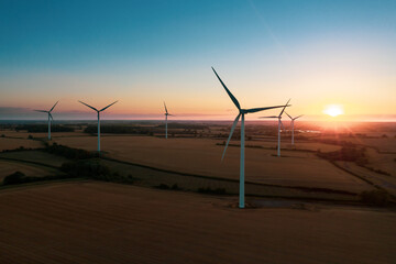 wind turbine farm sundown. wind turbines in rural landscape at sunset. aerial. drone.