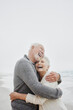 © Westend61 - Laughing senior couple embracing at the sea